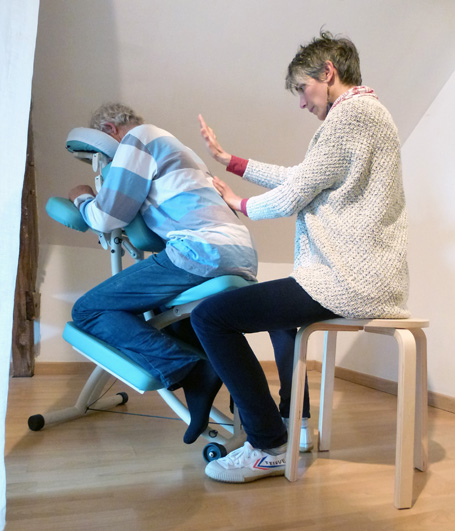 Soin énergétique du dos sur chaise de massage