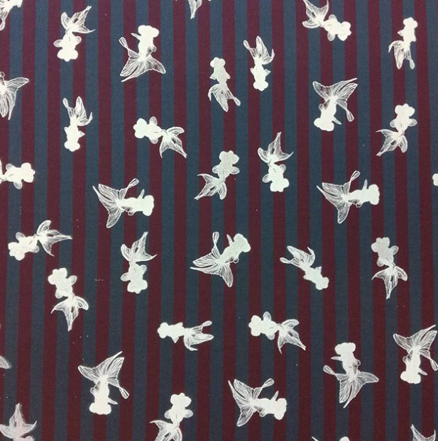 White fish repeat pattern on striped cotton fabric.