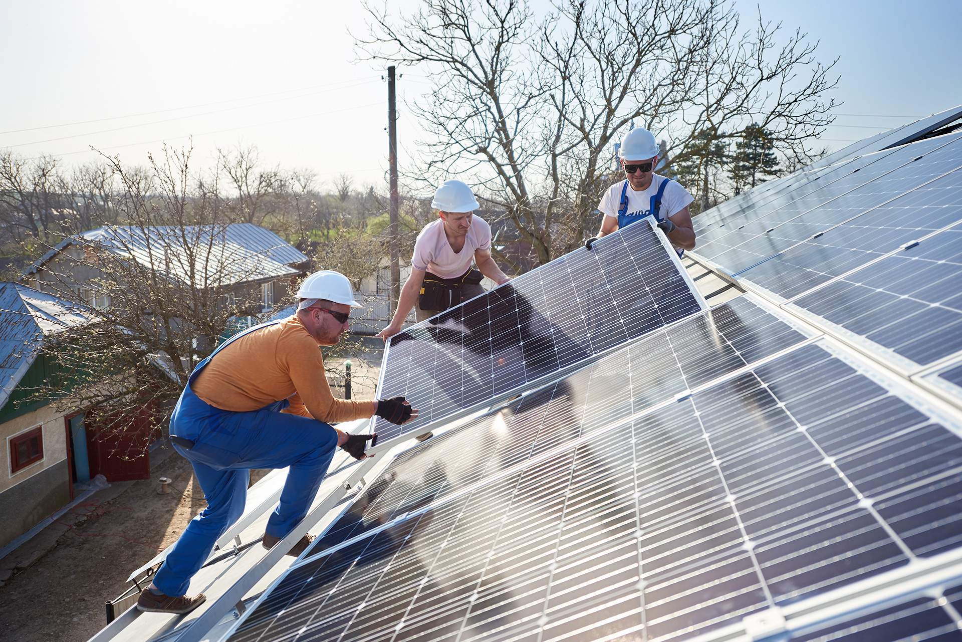 équipe qui installe des panneaux solaires sur toit en surimposition
